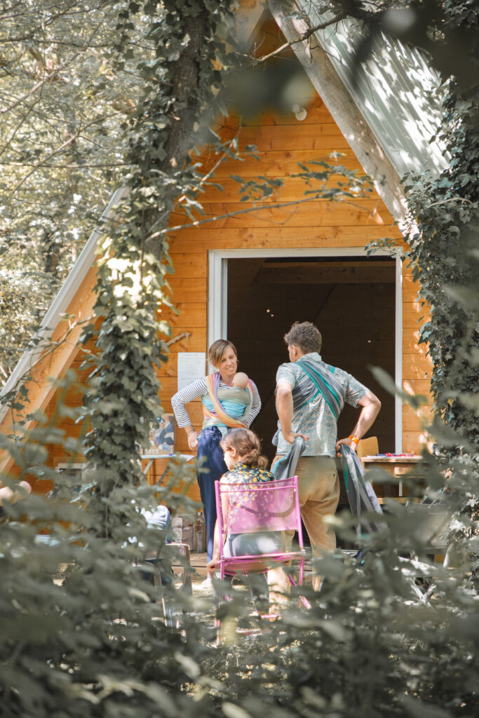 Aurore fait une démonstration de portage physiologique avec une écharpe de portage, à un papa