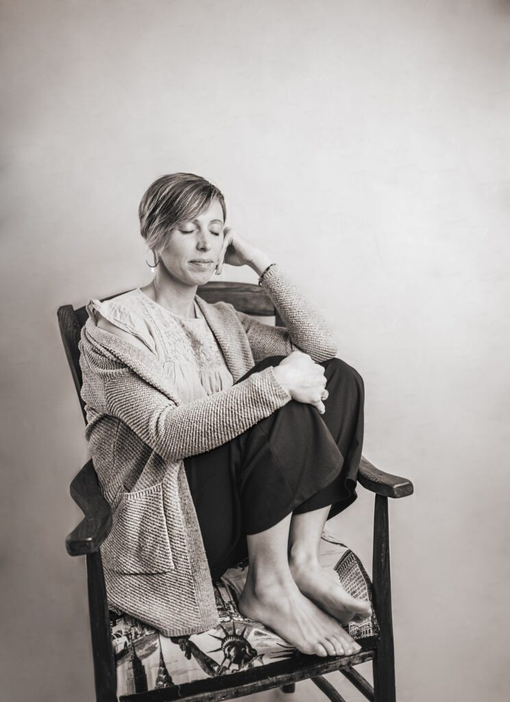 Aurore, accompagnante périnatale, assise sereinement les yeux fermés, symbole d’un soutien postnatal et d’un sommeil apaisé pour les familles.