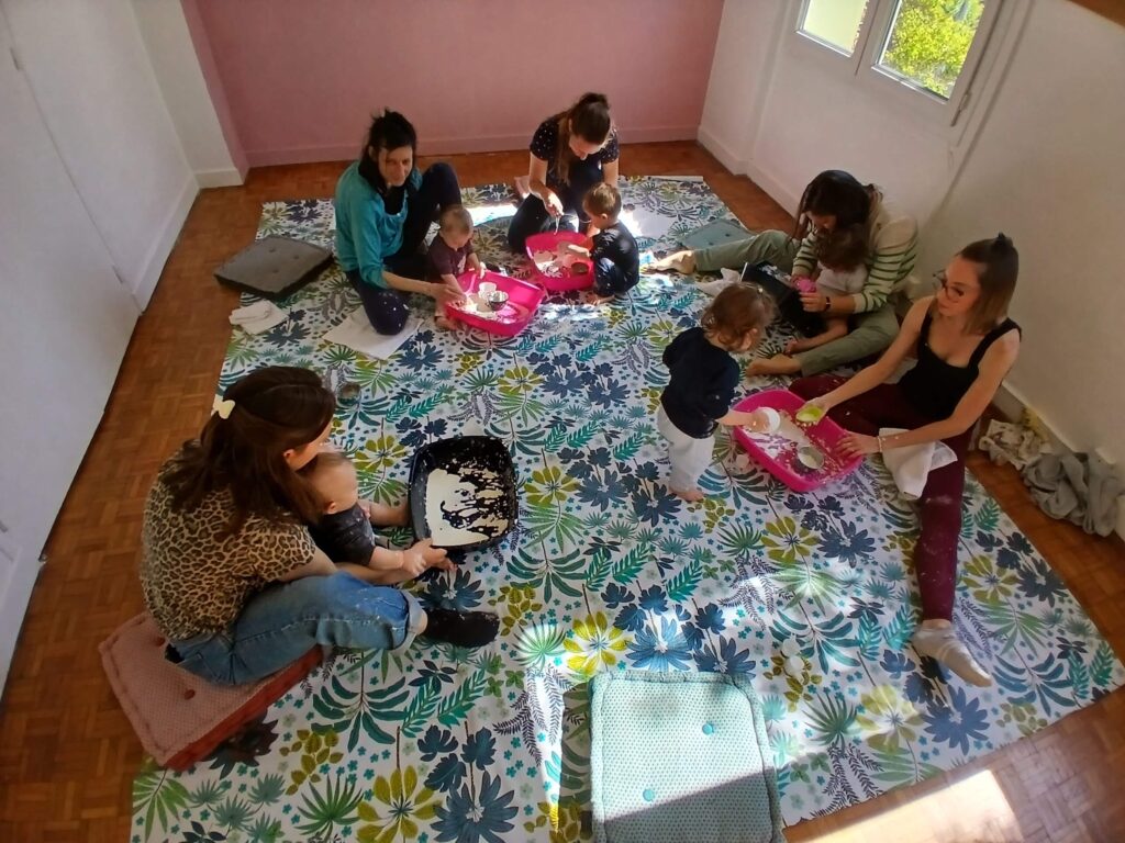 Mamans et jeunes enfants participant à un atelier d'éveil sensoriel animé par Aurore Mondelin à Valence.