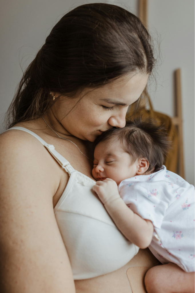 Une maman câlinant son bébé, illustrant un postpartum serein et mon soutien postnatal doux et personnalisé.